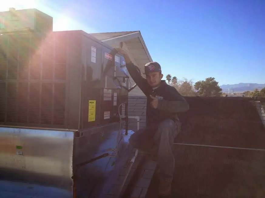 HVAC technician performing AC Tune-Up on a rooftop unit in Asheville